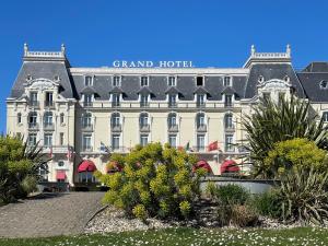a large building with a sign on the front of it at Les écuries à 12 mn de Cabourg in Goustranville