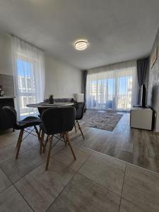 a living room with a table and chairs and a television at Coresi Mall Luxury Apartment in Braşov