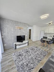 a living room with a television and a table at Coresi Mall Luxury Apartment in Braşov