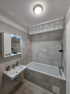 a bathroom with a bath tub and a sink at Coresi Mall Luxury Apartment in Braşov +7 photos