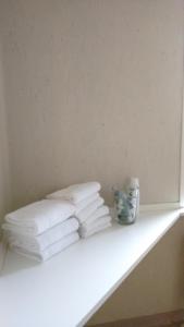 una pila de toallas blancas sentadas en un estante en Annex, en Frederikshavn