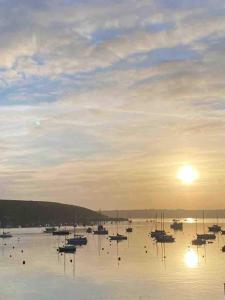 a group of boats sitting in the water at sunset at Stunning Waterfront Apartment With Spectacular Views & Parking at 'CAPTAINS LOFT' in Falmouth