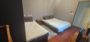 LanyuYawen Homestay 雅文民宿的有两张床和一面镜子的房间