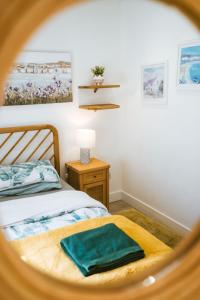 a bedroom with a bed with a green blanket at Breathtaking High Street Townhouse With Stunning Sea Views at 'The Old Fishermans Townhouse' in Falmouth