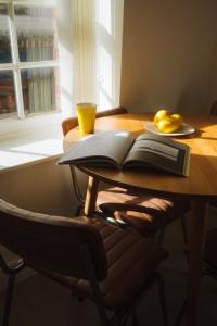a wooden table with a book and a plate of lemons on it at Breathtaking High Street Townhouse With Stunning Sea Views at 'The Old Fishermans Townhouse' in Falmouth +32 photos