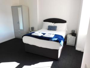 a bedroom with a bed with two towels on it at No 9 - Modern 3 Bedroom Apartment in Lanark Town Centre in Lanark +12 photos