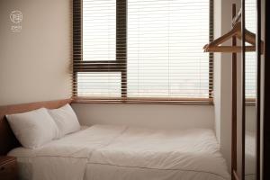 un lit assis dans une pièce avec une fenêtre dans l'établissement Zen Apartment - Nera Garden Hue, à Thôn Văn Dương