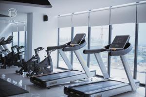 une salle de sport avec tapis de course et machines elliptiques dans l'établissement Zen Apartment - Nera Garden Hue, à Thôn Văn Dương