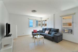 a living room with a couch and a tv at Tu Alojamiento En Playa Paraiso in Adeje