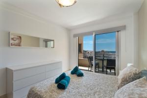 a bedroom with a bed with blue pillows on it at Tu Alojamiento En Playa Paraiso in Adeje +22 photos