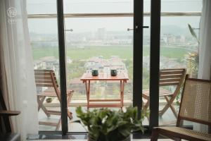 une table et des chaises sur un balcon avec vue dans l'établissement Zen Apartment - Nera Garden Hue, à Thôn Văn Dương 23 autres photos