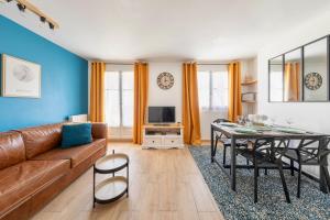 a living room with a couch and a table at Séjour magique à 10 min de Disneyland- Appartement cosy avec terrasse & parking privé in Bailly-Romainvilliers