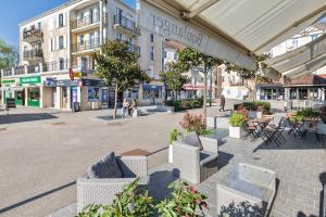 a city street with chairs and tables and buildings at Séjour magique à 10 min de Disneyland- Appartement cosy avec terrasse & parking privé in Bailly-Romainvilliers