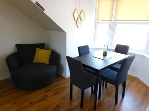 a dining room with a table and chairs and a couch at No 11 - Contemporary 2 Bedroom Apartment in Lanark Town Centre in Lanark