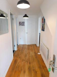 an empty hallway with a hard wood floor and white walls at No 11 - Contemporary 2 Bedroom Apartment in Lanark Town Centre in Lanark