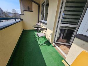 ein Balkon mit Tisch und Stühlen auf dem Boden in der Unterkunft Green Kabaty Apartment 5 in Warschau