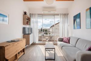 a living room with a couch and a large window at AS25806-P2 cabine duplex avec terrasse et parking in Le Grau-du-Roi