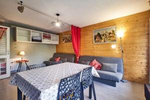 a dining room with a table and a couch at Charmant studio en montagne à Allevard - 30 m² avec balcon in Allevard