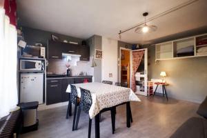 a kitchen with a table with chairs and a kitchen with a table and a kitchen at Charmant studio en montagne à Allevard - 30 m² avec balcon in Allevard