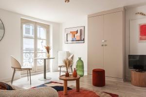 a living room with a couch and a tv at Le Beauvoir - Refuge Arty du XVIIIe siècle in Blois
