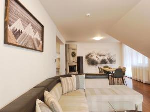 una sala de estar con un sofá y una mesa en Apartments Tatra Olla - Tatranská Lomnica, en Tatranská Lomnica