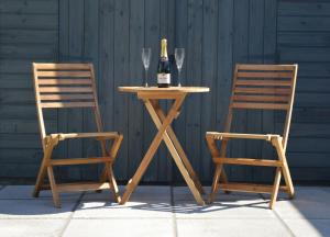 a table with a bottle of wine and two chairs at Greenfield Studio in Cardiff