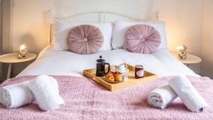 Una cama con toallas y una bandeja de comida. en Burgess Beach House, en Caister-on-Sea 41 fotos más