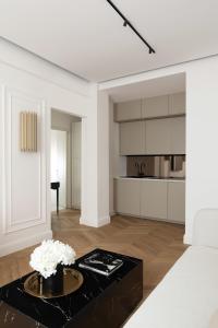 a white living room with a black coffee table at Flòris Luxury Apartment NEW in Florence