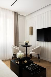 a hotel room with a table and chairs and a television at Flòris Luxury Apartment NEW in Florence