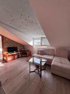 un salon avec un canapé et une table dans l'établissement Sasha Duplex Apartment, à Skopje