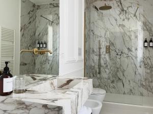 a marble bathroom with a sink and a toilet at Flòris Luxury Apartment NEW in Florence +18 photos