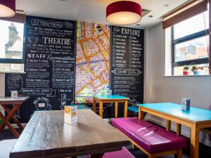 a restaurant with two tables and a chalkboard wall at Astor Oxford Street in London