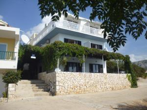 a white house with a stone wall and stairs at Apartment Mia in Hvar