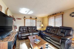 un soggiorno con mobili in pelle e una TV a schermo piatto di Cottage Haven a New Rome