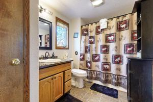 e bagno con lavabo, servizi igienici e tenda per la doccia. di Cottage Haven a New Rome Altre 15 foto