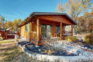 una baita di tronchi con veranda e patio. di Cottage Haven a New Rome
