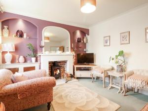 a living room with a fireplace and a tv at Lavender Cottage in Louth