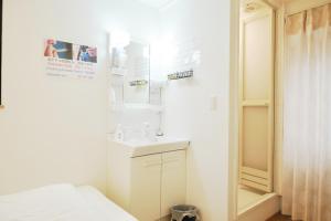 een witte badkamer met een wastafel en een spiegel bij Hananogo Ikebukuro - Vacation STAY 09224v in Tokyo +10 foto's