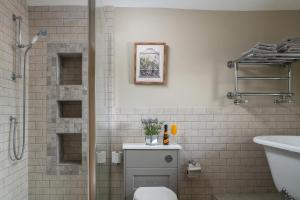 Un baño con ducha, inodoro y lavabo. en Little Gem Cottage Luxury cottage Bourton, dog friendly, parking, Gdn, en Bourton on the Water