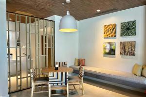 a dining room with a table and chairs and a bench at Fairfield by Marriott San Jose Airport Alajuela in Alajuela City