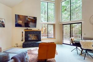 a living room with a fireplace and a table at Enchanted Meadows in Gualala