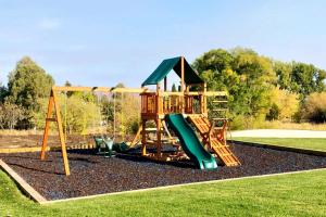 a playground with a slide in a park at Hillside Farm’s Cottages in Paris