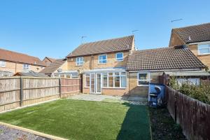 einen Hinterhof mit kleinem Rasen vor einem Haus in der Unterkunft Host & Stay - Venture Park Villas in Kettering