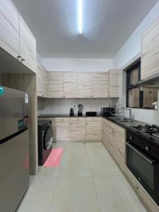 a large kitchen with wooden cabinets and a stove at Aramis Apparments in Nairobi