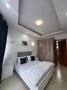 a bedroom with a large white bed in a room at Aramis Apparments in Nairobi +21 photos