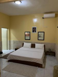 a bedroom with a large bed with white sheets at Chez saly in Saint-Louis