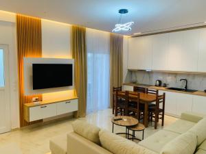 a living room with a couch and a table and a kitchen at Vila Feimi in Ksamil