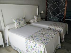 two beds in a room with two beds sidx sidx sidx at Suites BELLAHELLIN in Hellín