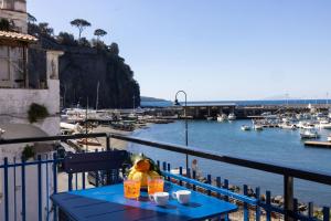 a blue table on a balcony with a view of a harbor at Estate4home - Mary B in Piano di Sorrento