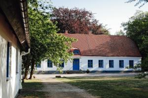 a large white building with a red roof at Äspögården Bed & Breakfast in Klagstorp